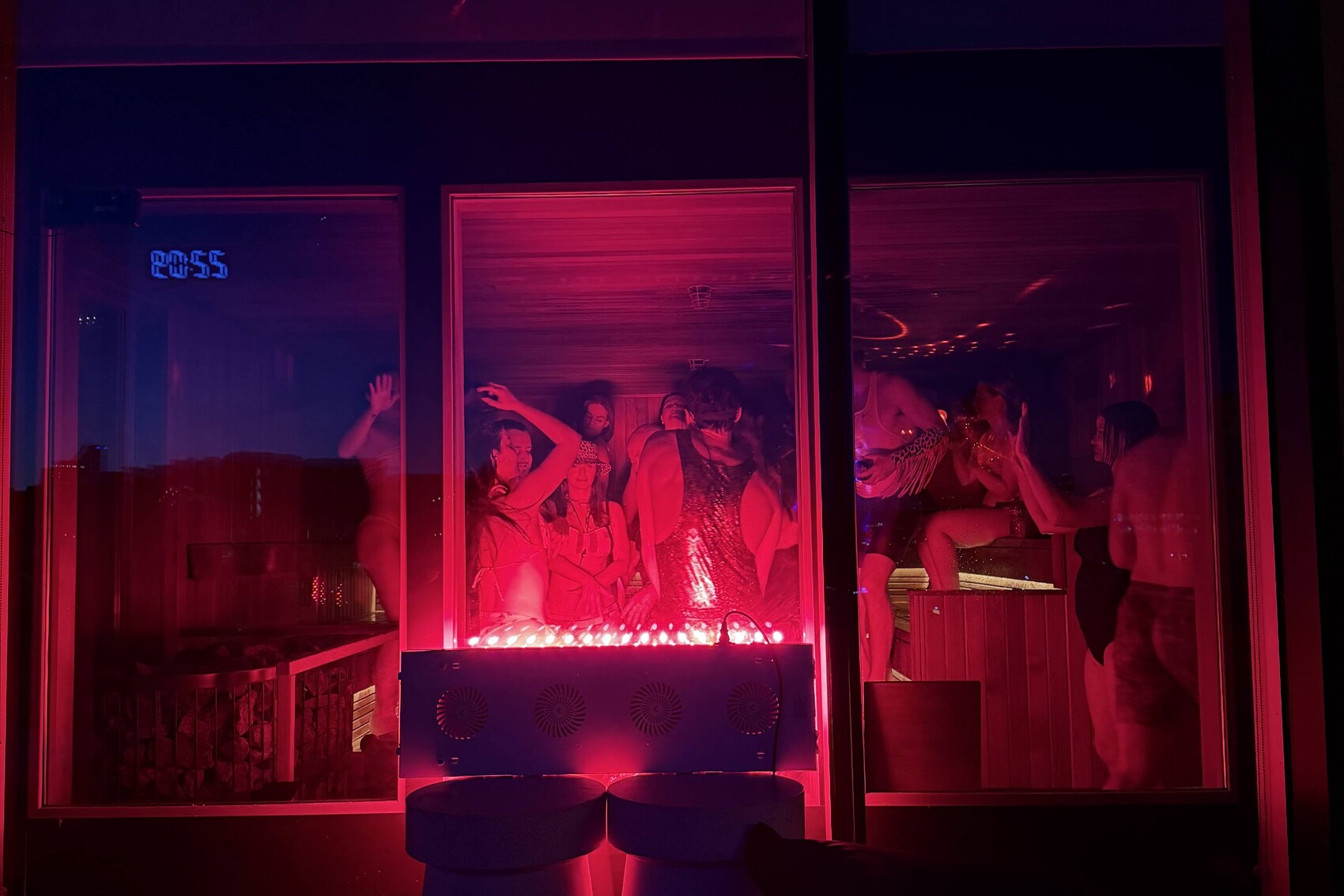 People dancing together inside a glowing red sober rave sauna