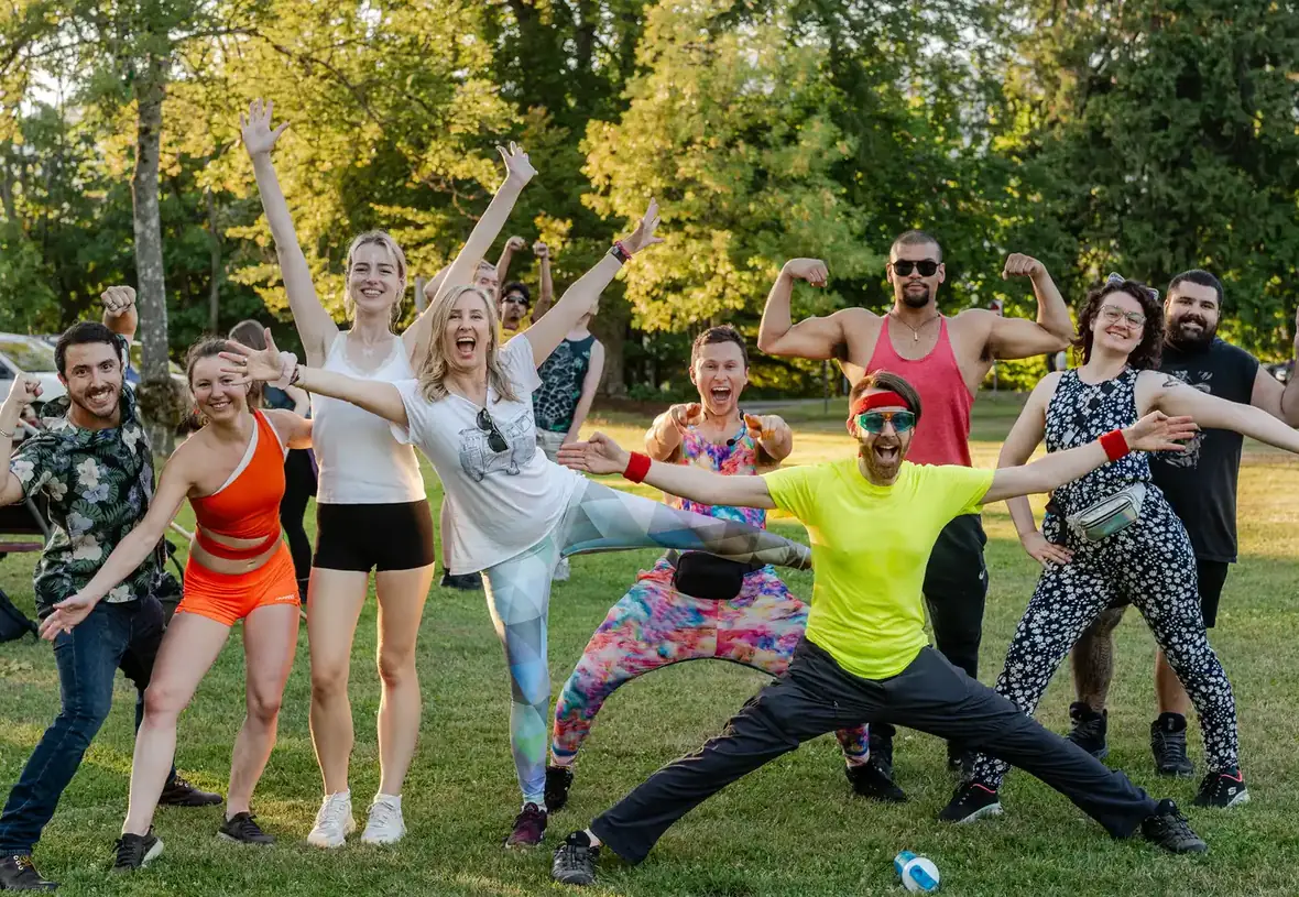 A joyful group of people outdoors celebrating together at Joymaker Camp